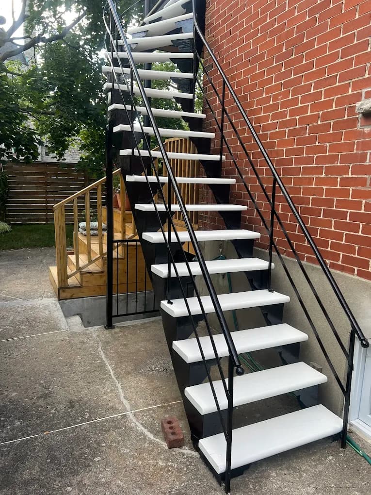 Escalier extérieur noir avec marches blanches fraîchement peintes
